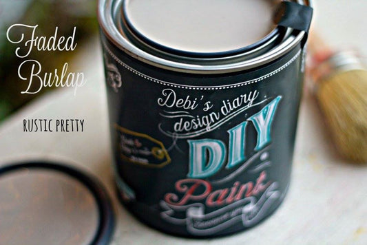 An open can of DIY Paint Co. brand chalk paint in the color "Faded Burlap" sitting on a table.