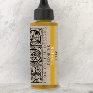 An unopened bottle of IOD "Turmeric Ink" against a white background.