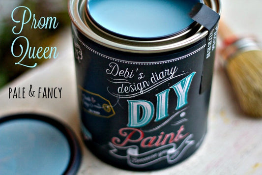 A paint can labeled 'Prom Queen' with a black outside. The paint is a blue color.