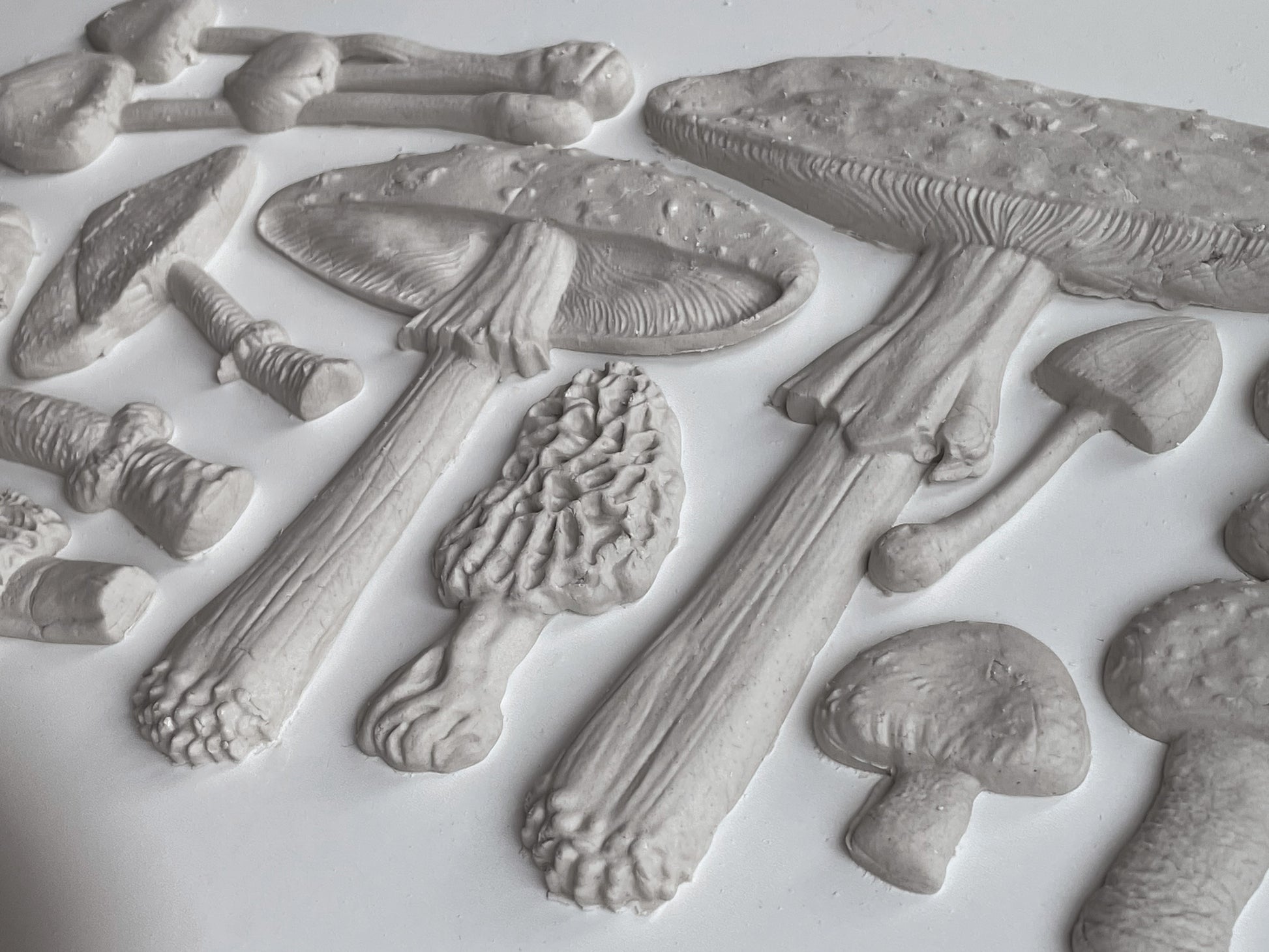 Clay castings of mushrooms from the IOD "Toadstool" mould, sitting on a white table.