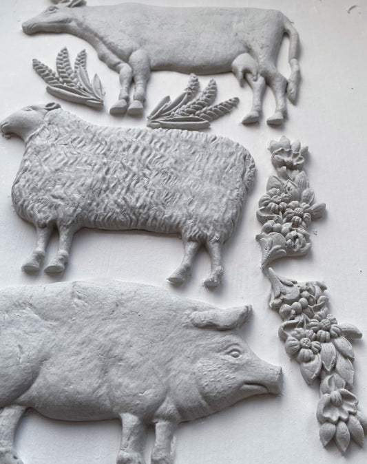 An air dry clay casted cow, sheep, and pig, made from the IOD Village Market mould.