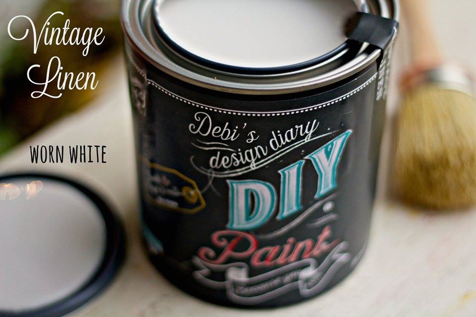 An open can of Vintage Linen paint, alongside a brush, indicating the paint is intended for a DIY project.